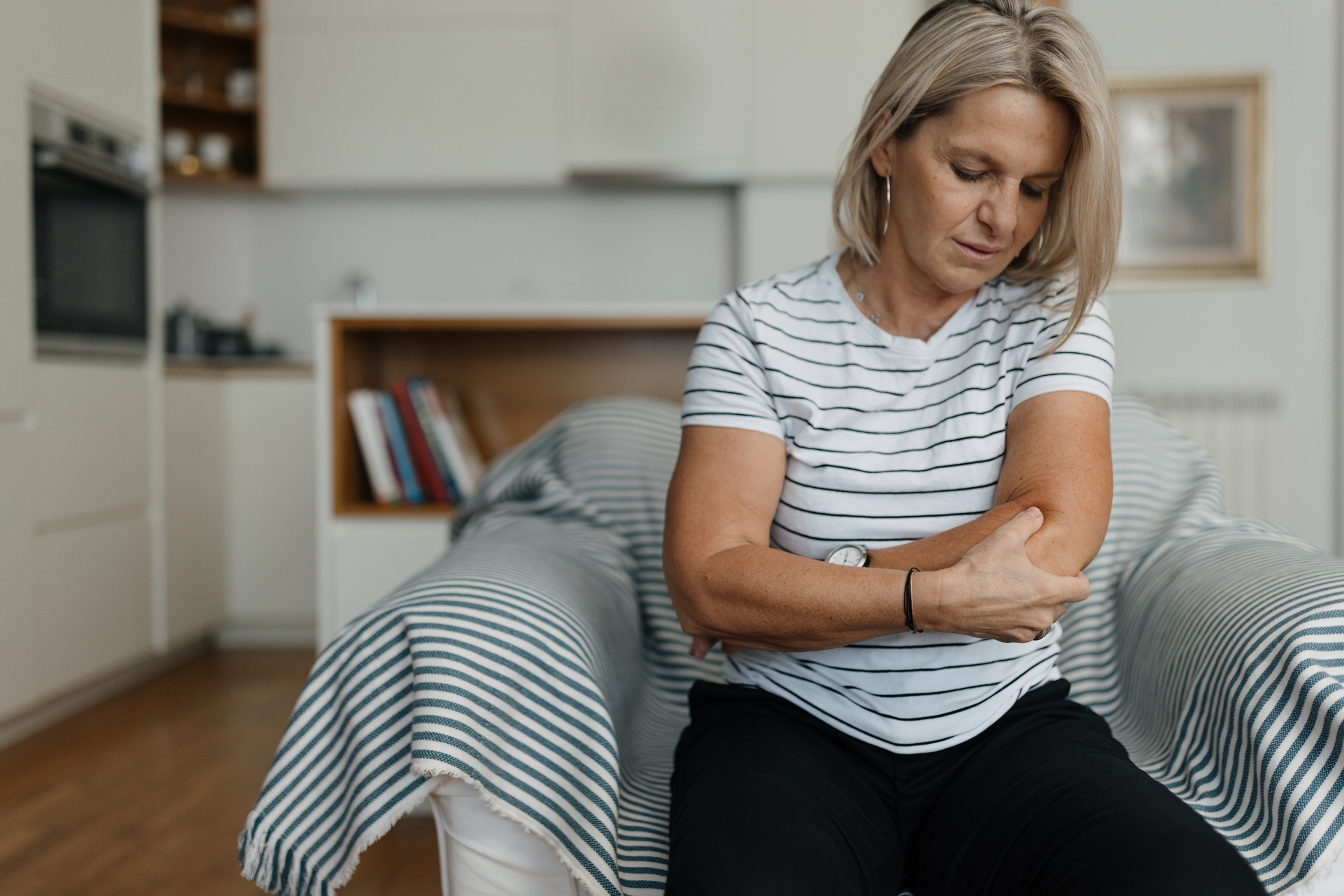 Person with elbow pain requiring specialized chiropractic treatment in Costa Mesa